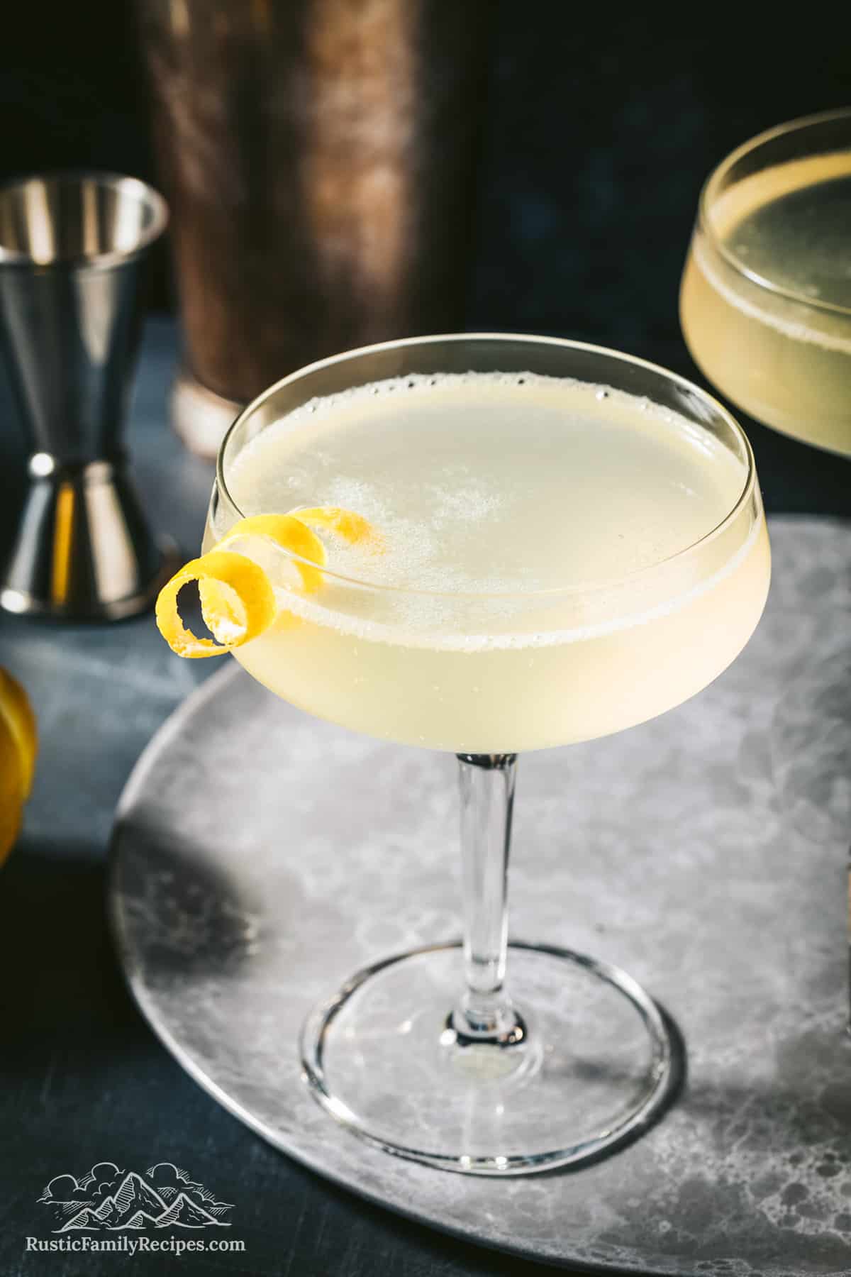 Bees knees cocktail with a lemon twist