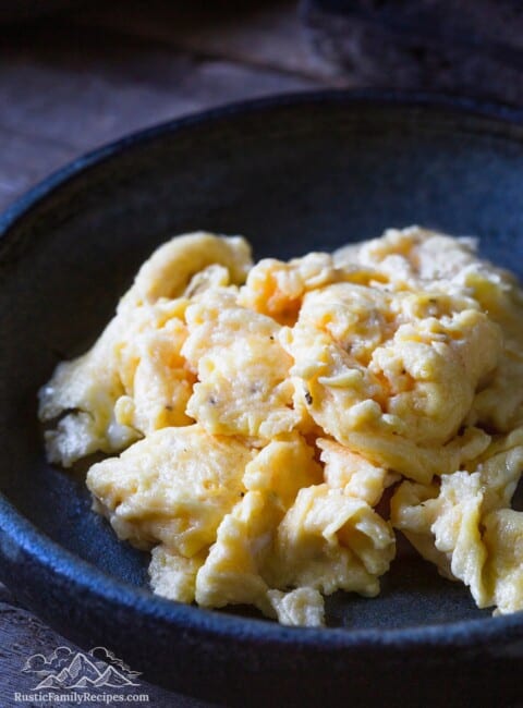 A rustic plate with fluffy scrambled eggs in a pile