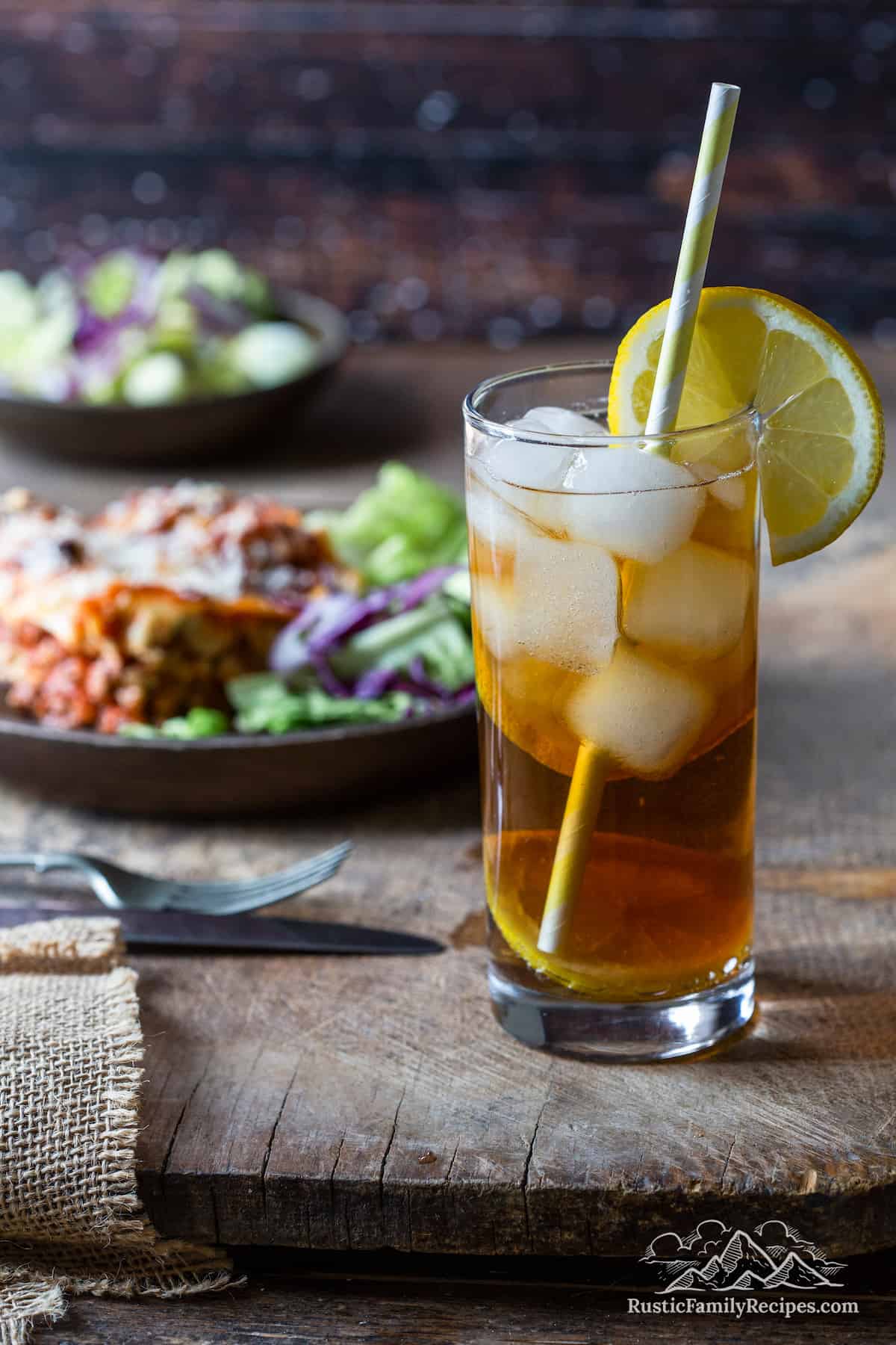 Arnold Palmer drink with a plate that has lasagna and salad