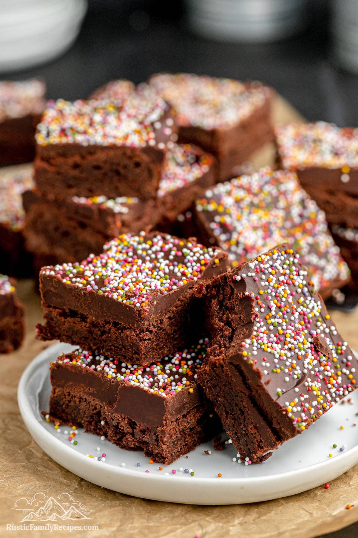 A plate of three nearly cosmic brownies with more brownies behind it