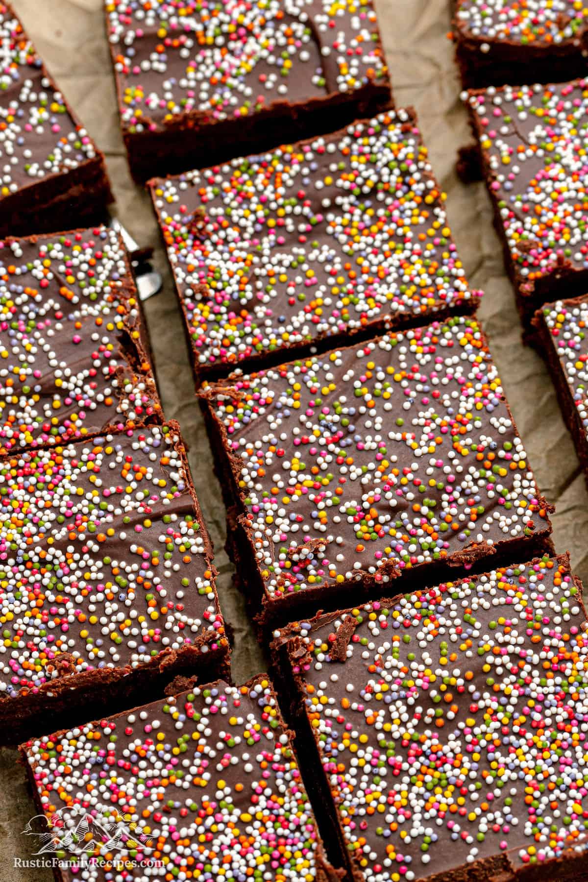 A close-up shot of frosted brownies with nonpareil sprinkles on top