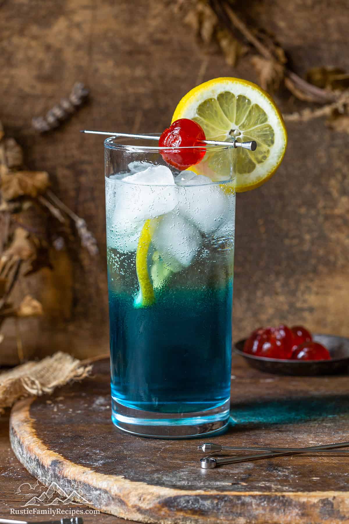 Blue AMF cocktail with a lemon slice and cherry