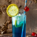 Blue AMF cocktail with a lemon slice and cherry