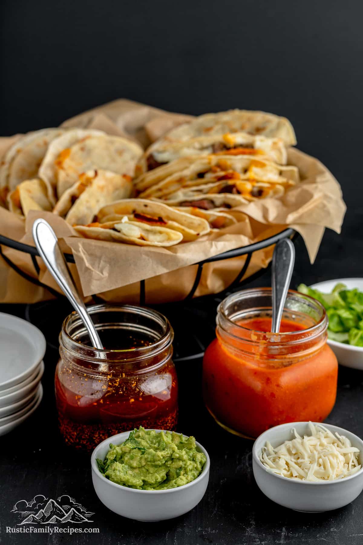 A basket of tacos with guacamole and salsa macha