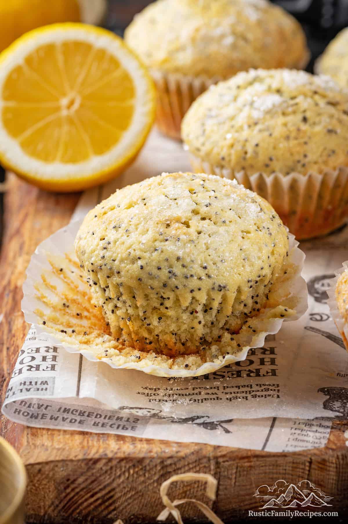 Sourdough discard lemon poppy seed muffins, one with the wrapper pulled back