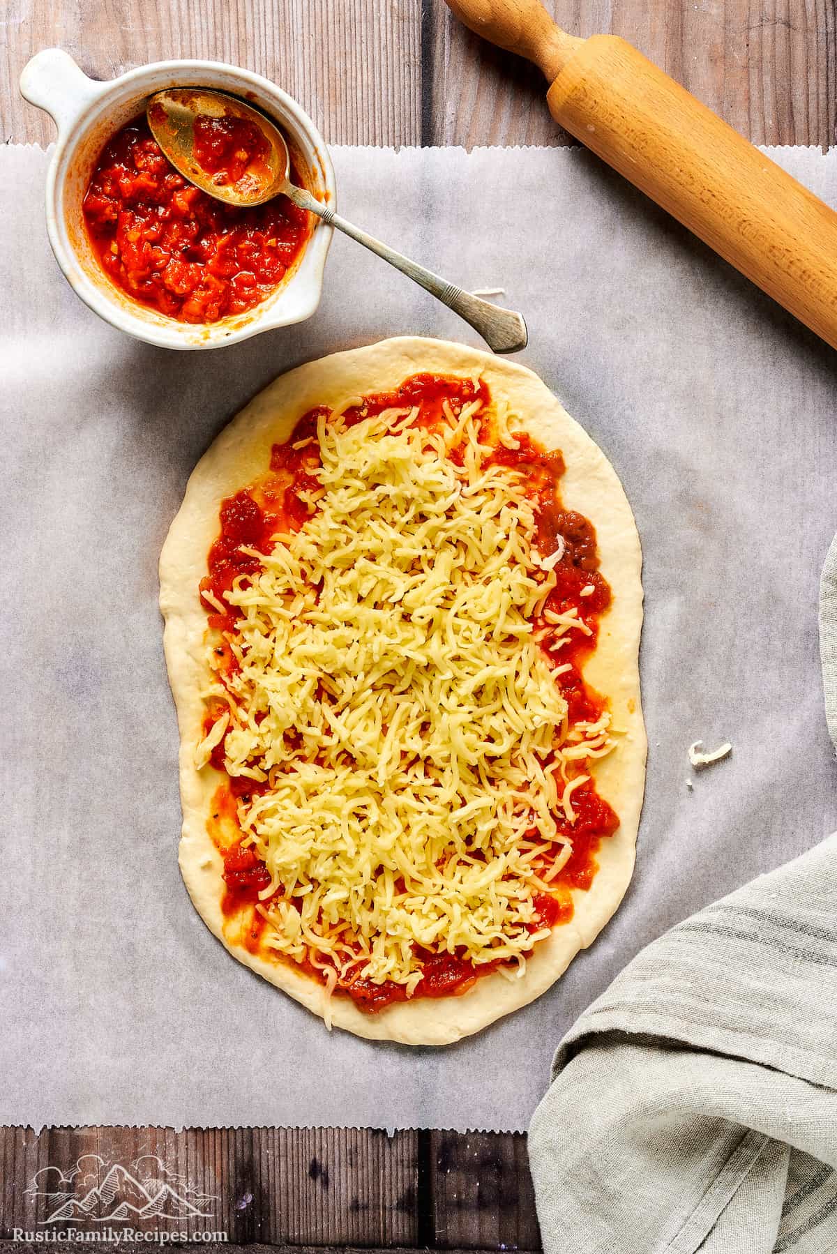 Rolled out pizza dough with sauce and cheese