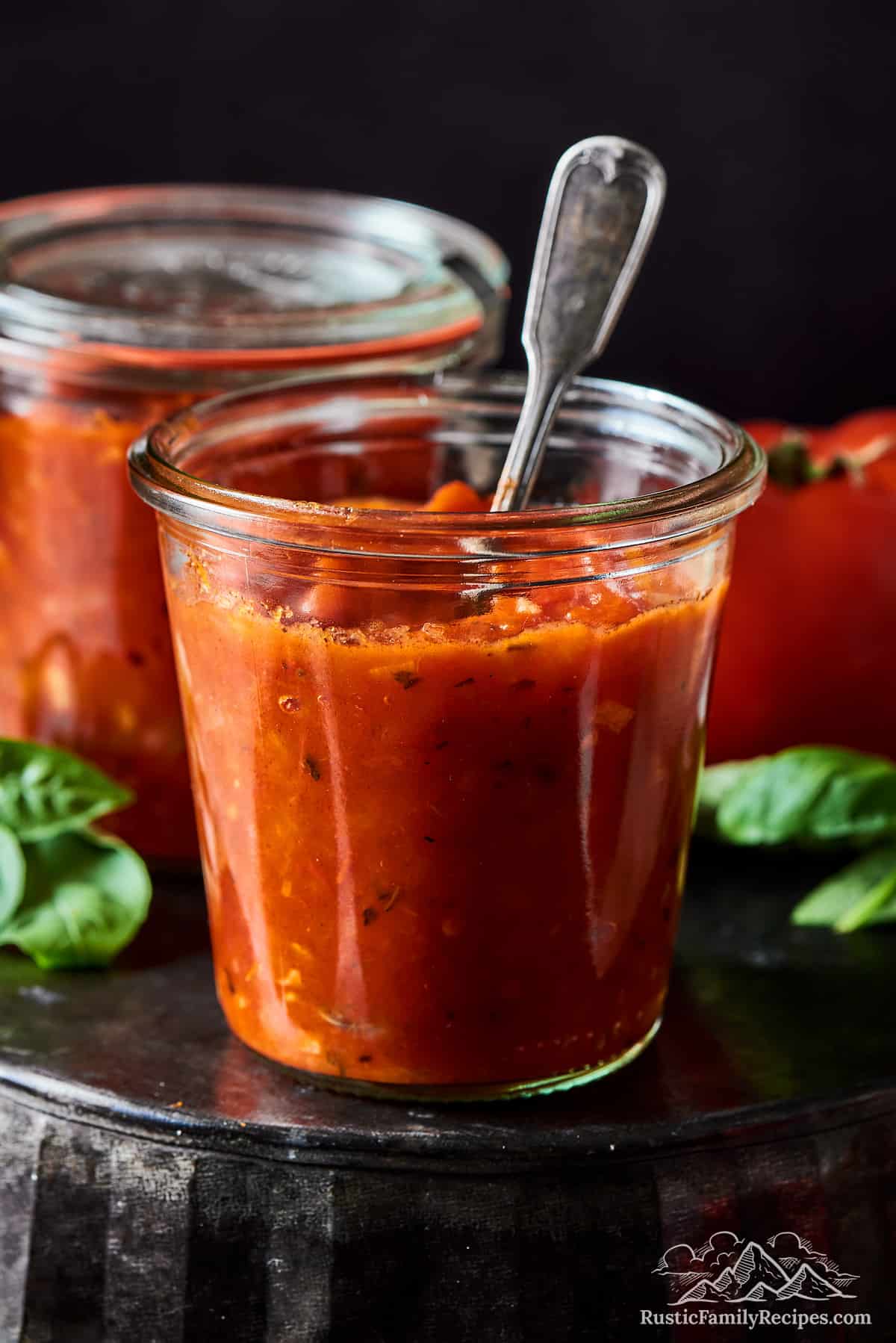 Pasta sauce in jars, one with a spoon