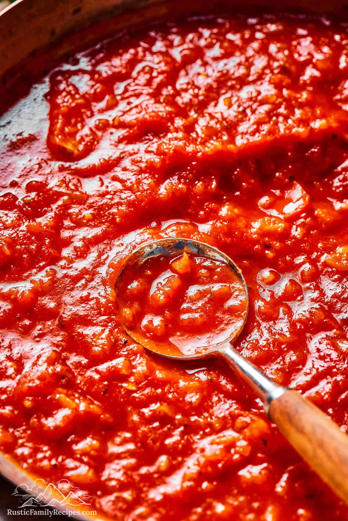 Pasta sauce in a pan with a spoon
