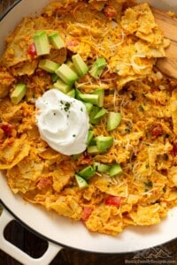 Sweet potato migas in a pan topped with avocado and sour cream