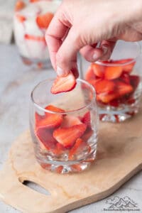 Adding strawberries to a glass