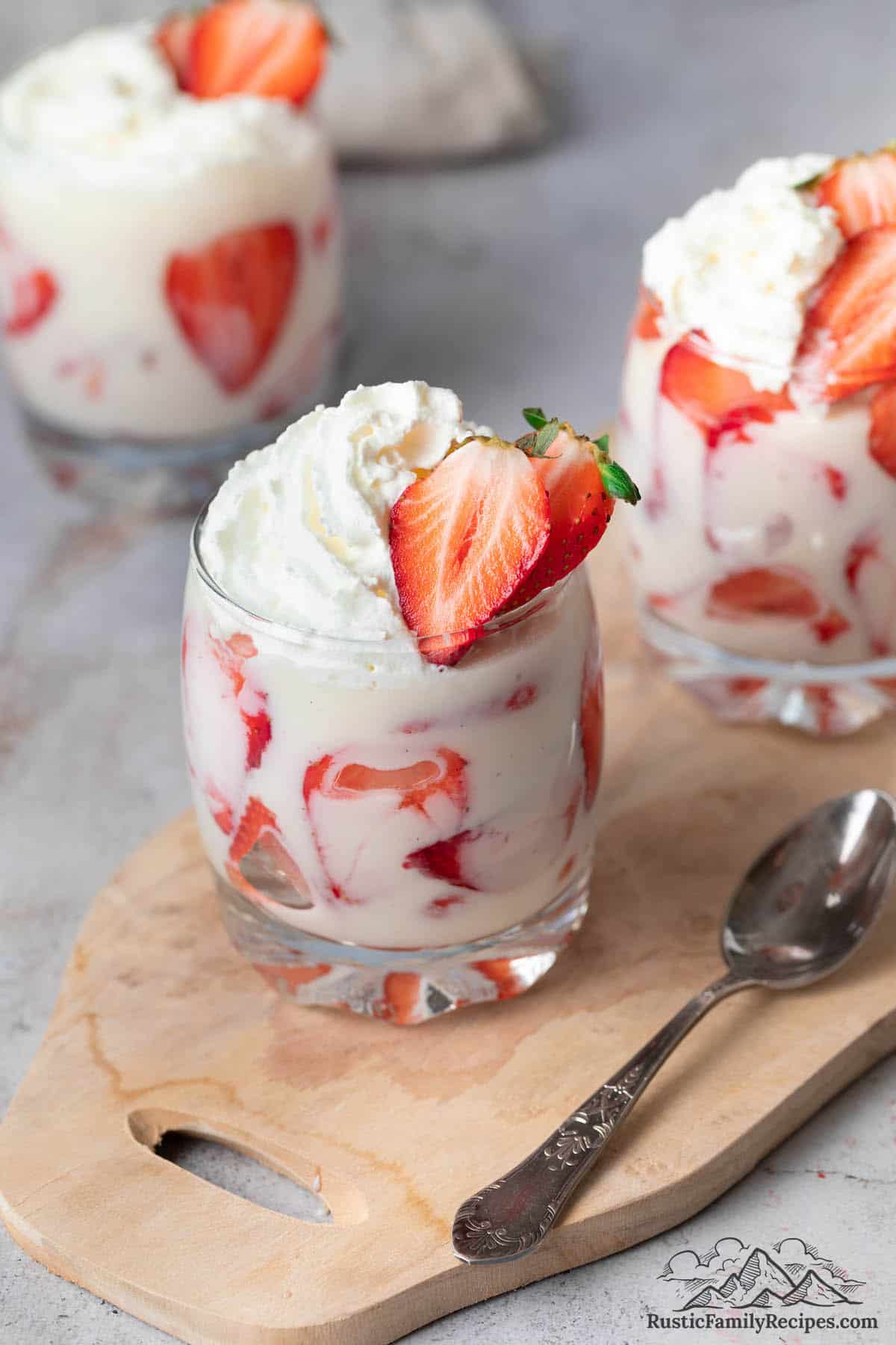 Strawberries, cream and whipped cream in three glasses
