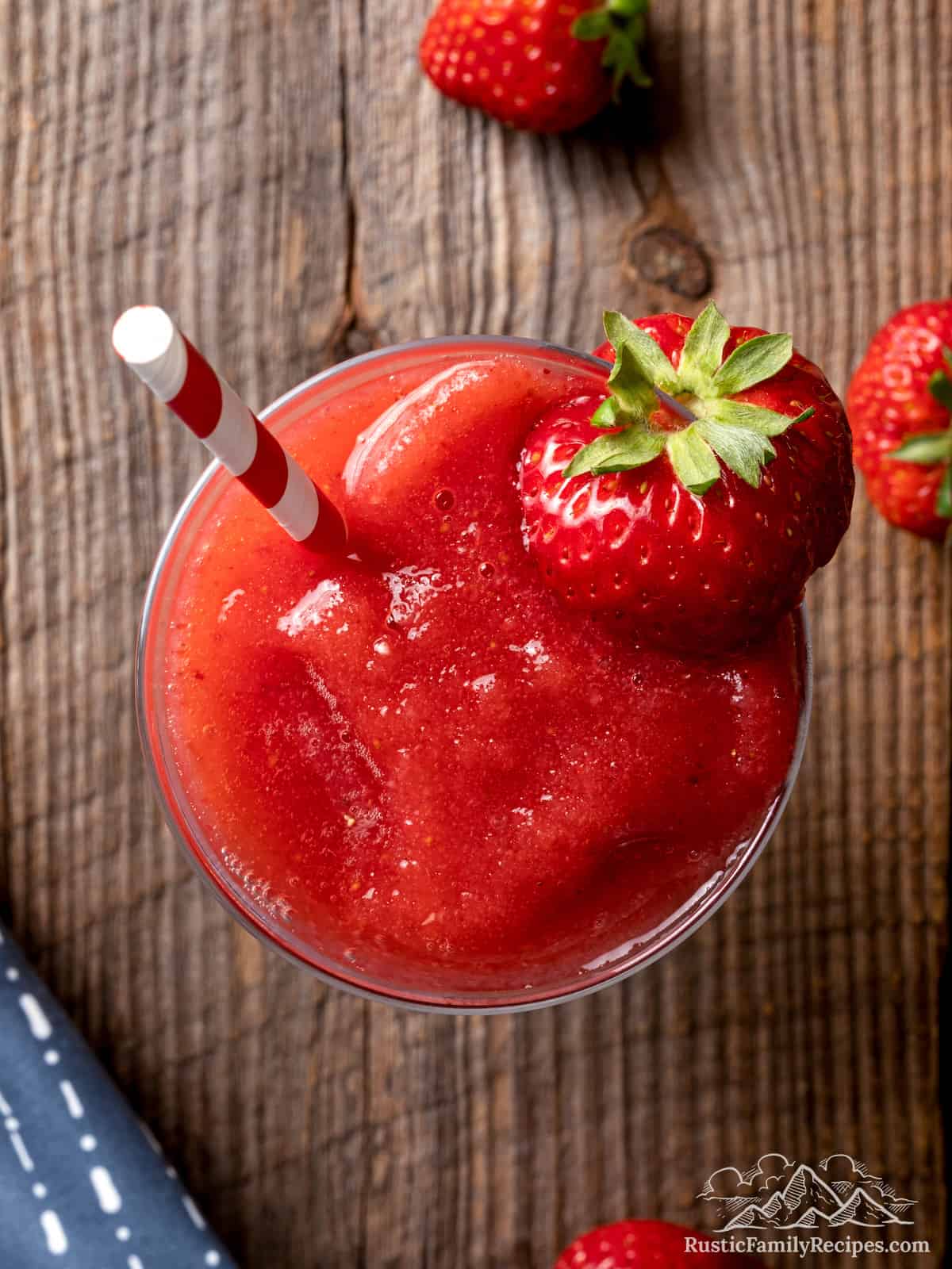 Top view of a Strawberry Daiquiri with a fresh berry and straw