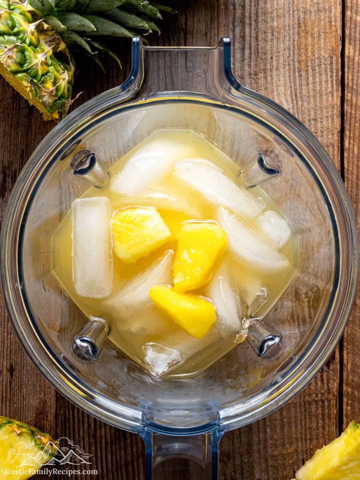 Pineapple, ice, coconut and rum in a blender