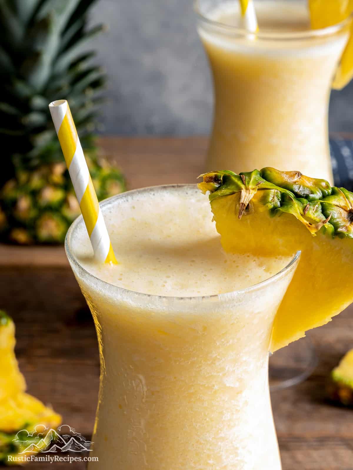 Close up of two pina coladas in hurricane glasses