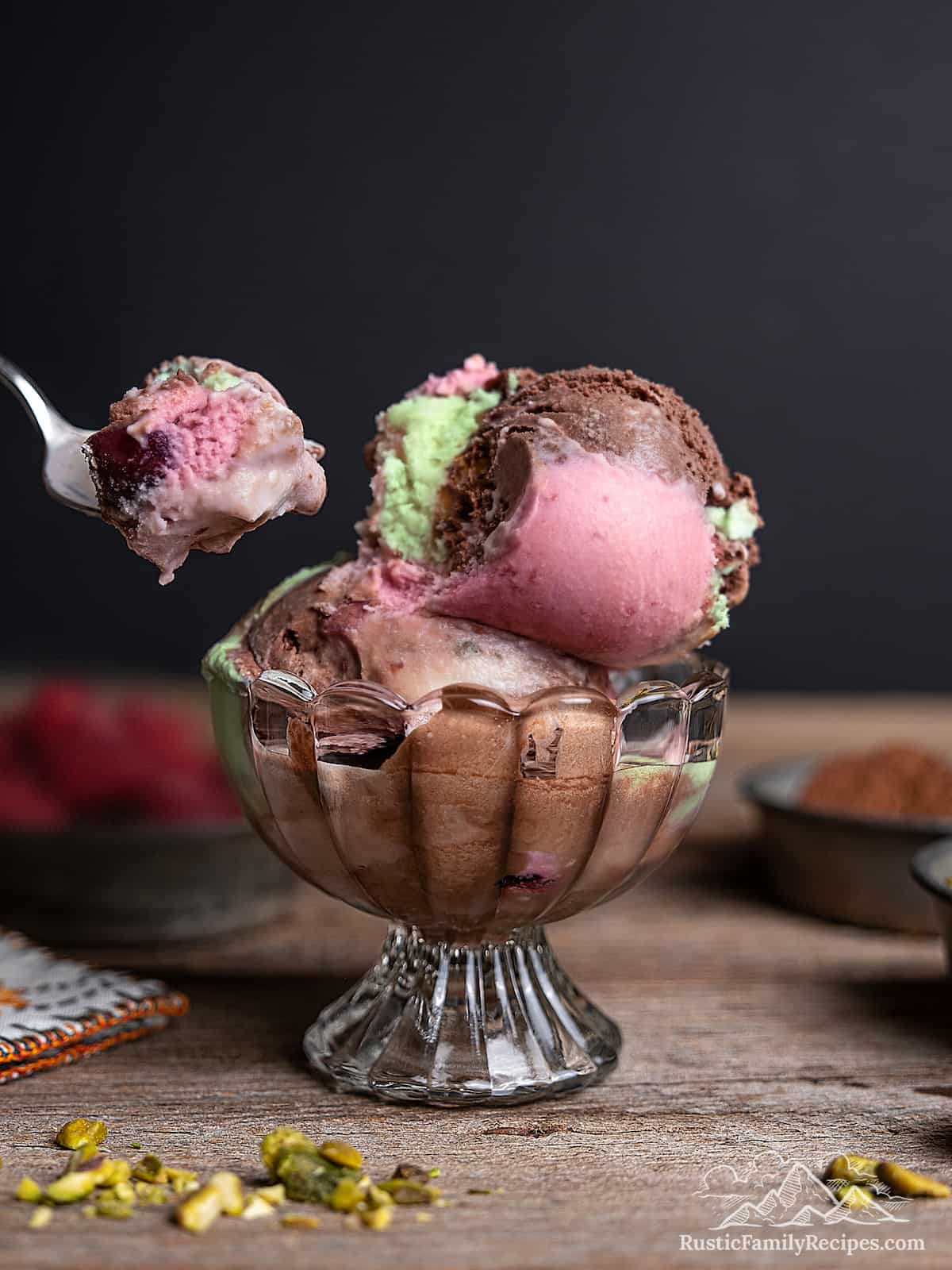 A spoonful of spumoni ice cream next to a bowlful.