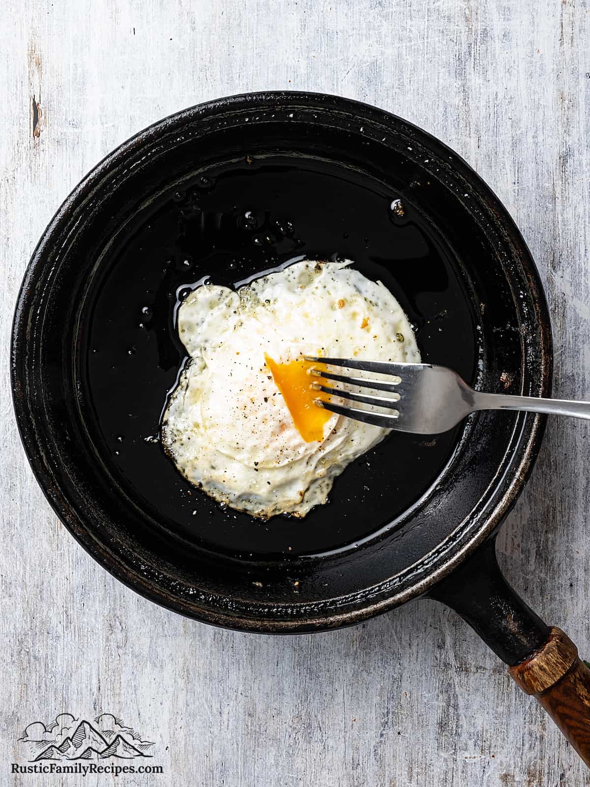 A fork poking an over medium egg
