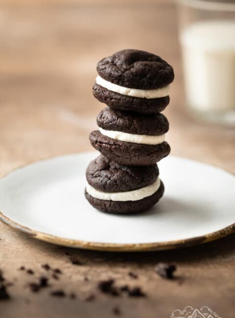 A stack of three Oreo whoopie pies on a white plate.