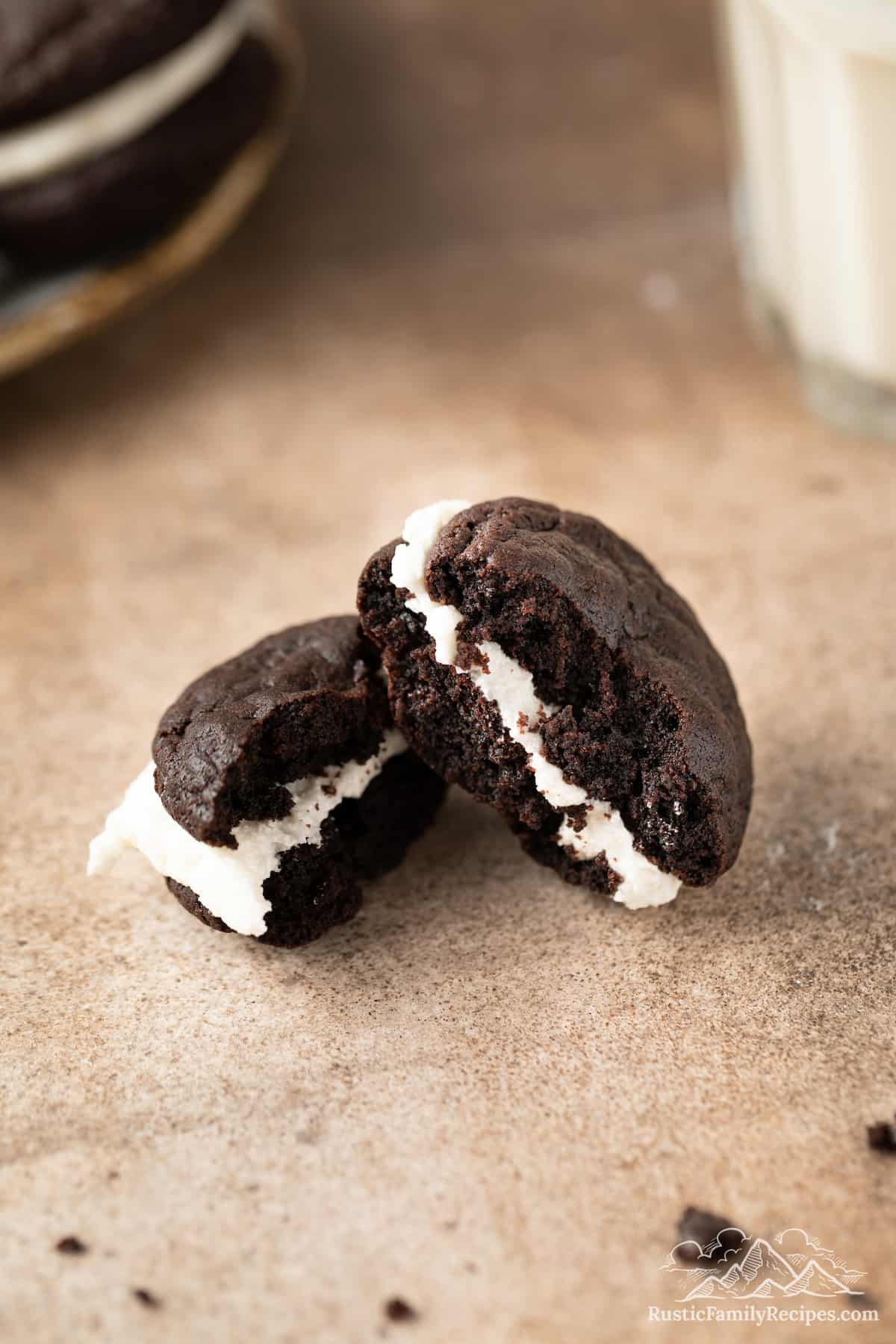 Two halves of an Oreo whoopie pie revealing the layers of chocolate cookie and vanilla cream filling.