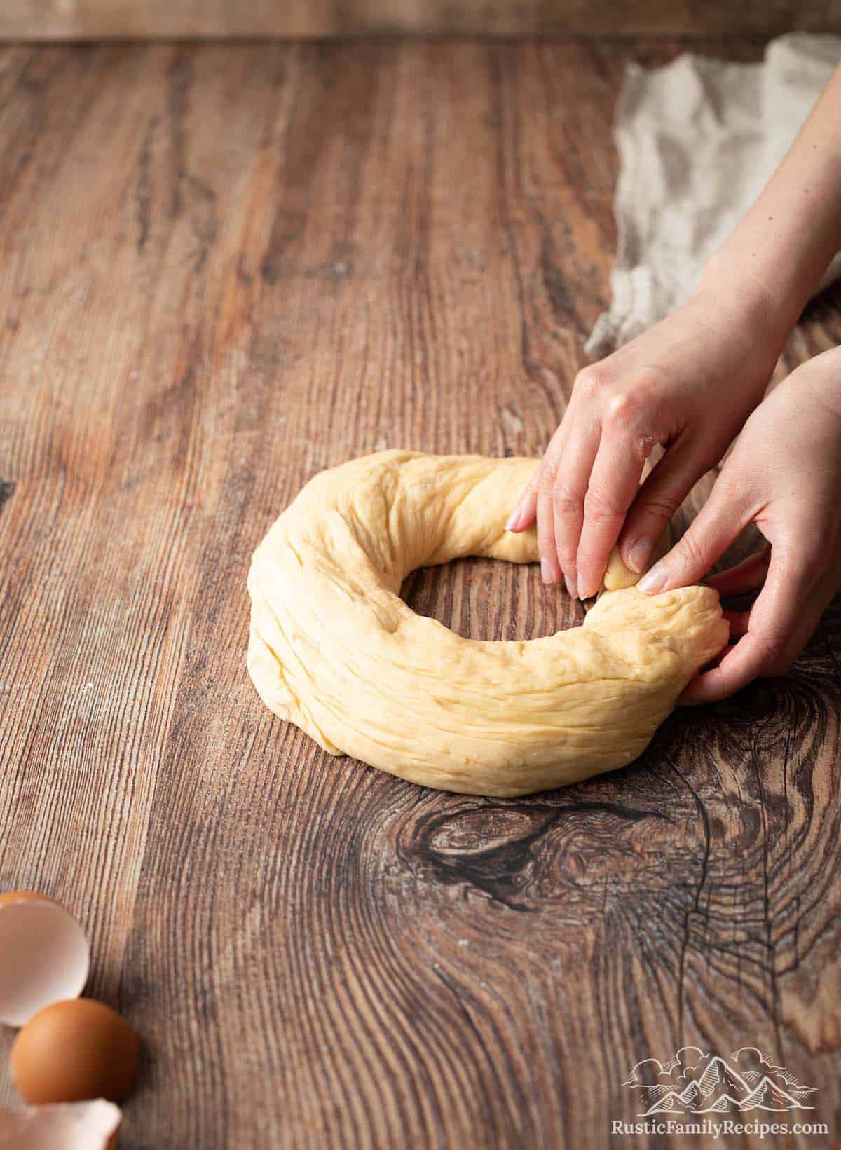 A roll of dough being formed into a circle