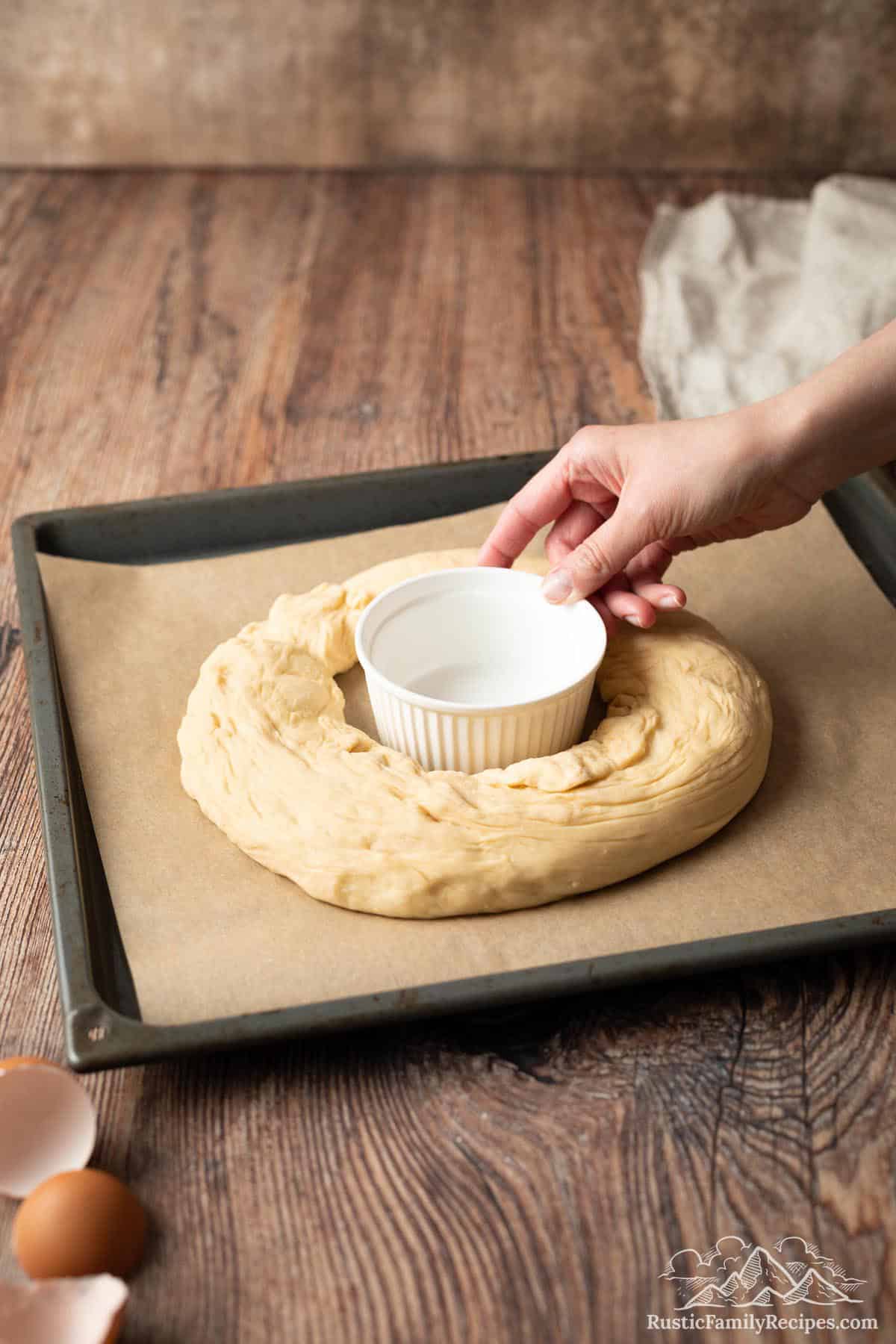 A large bowl placed in the center of a circle of dough