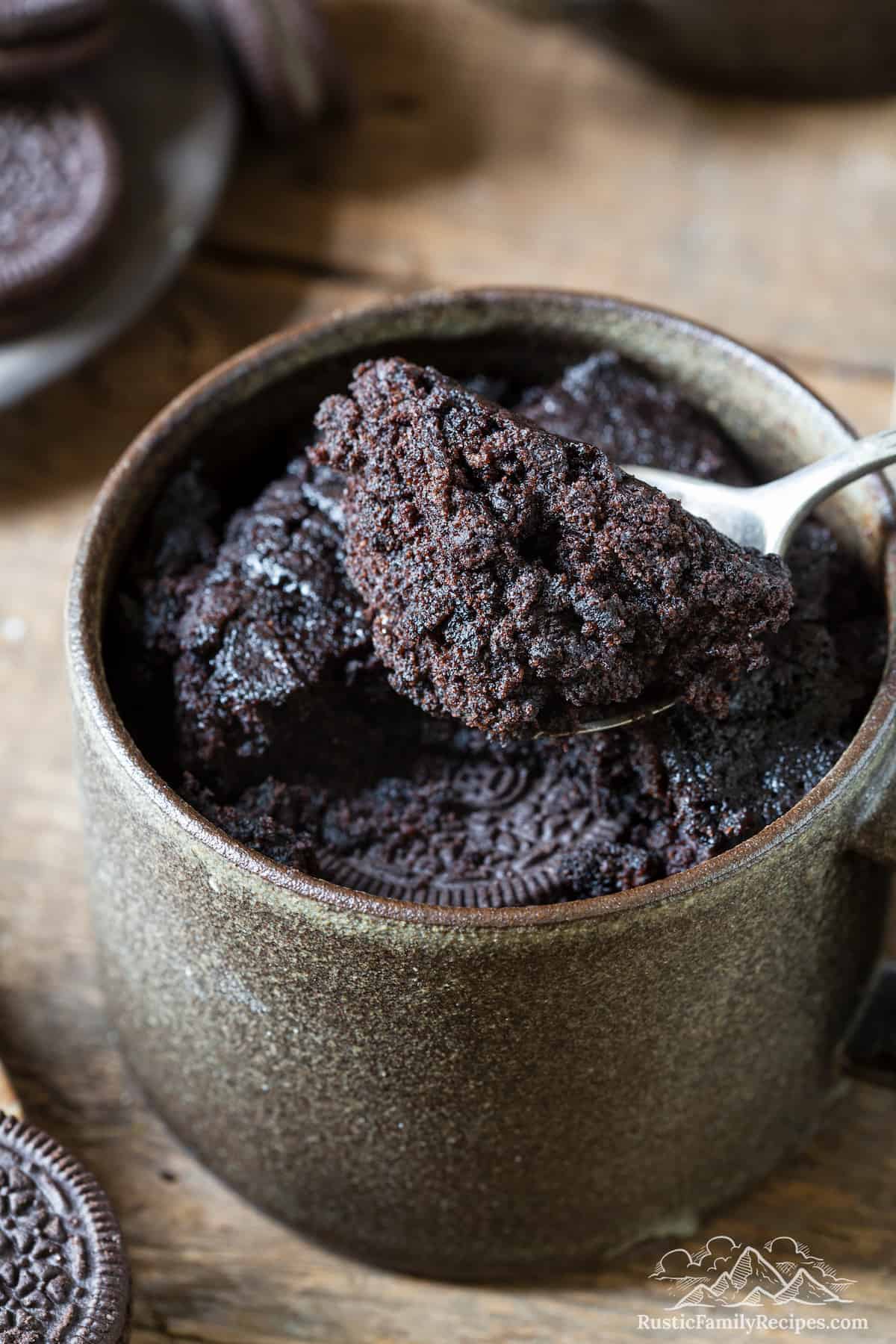 Oreo mug cake with a spoon taking a scoop out