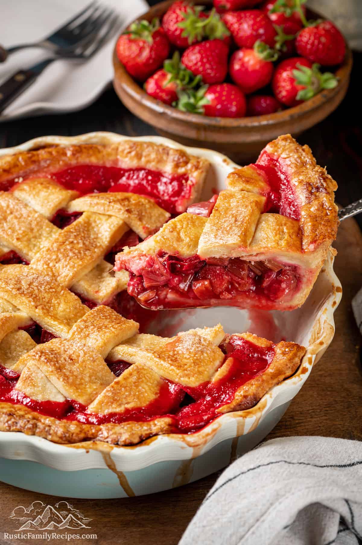 A slice of strawberry rhubarb pie is lifted from a pie pan.