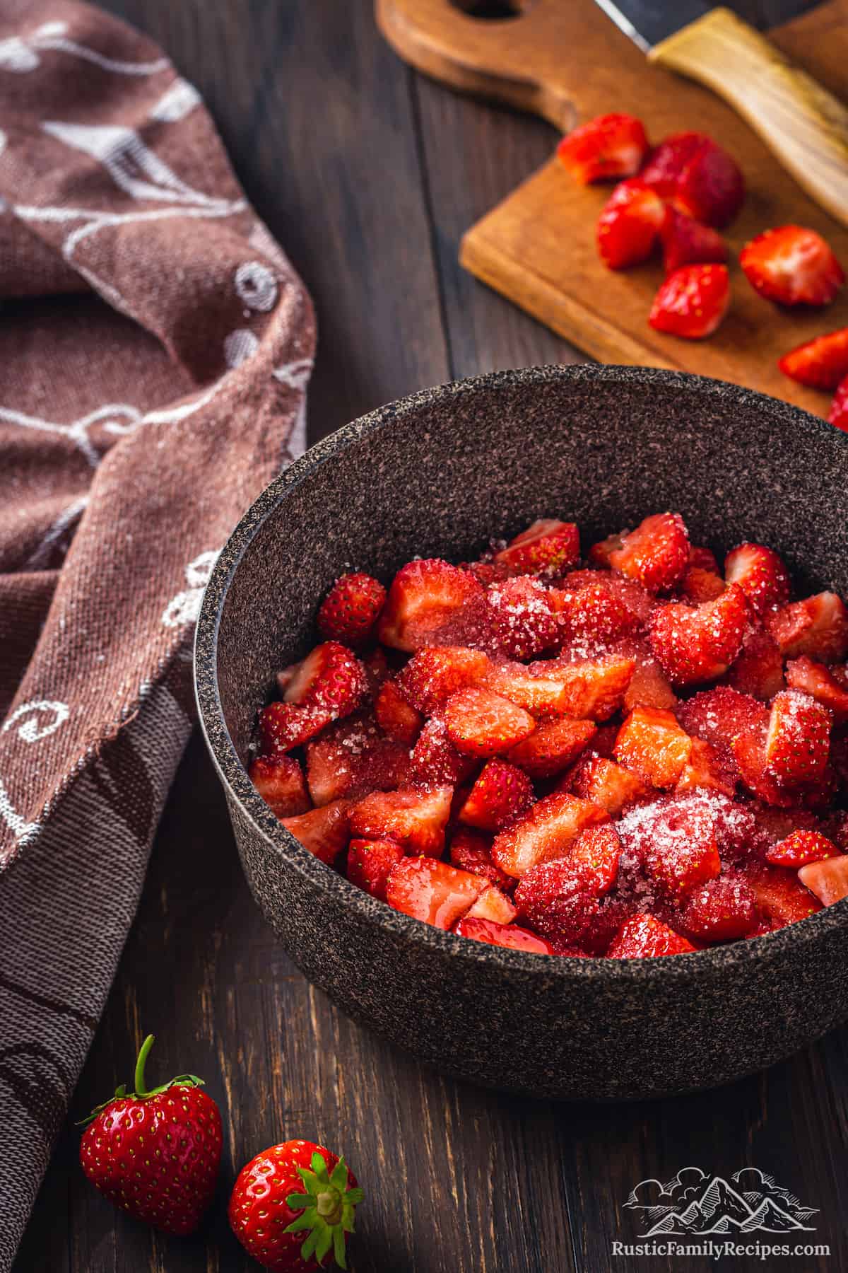 Chopped strawberries in a cast iron saucepan, sprinkled with sugar.