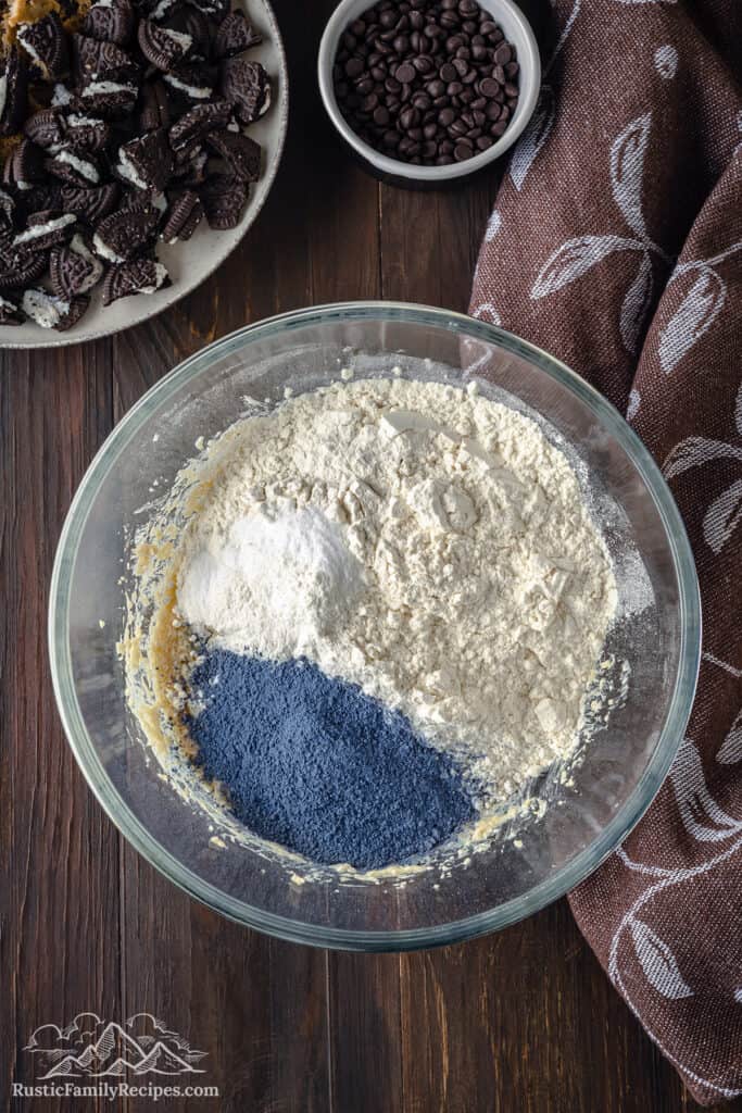 Dry ingredients for blue cookie monster cookies in a glass bowl