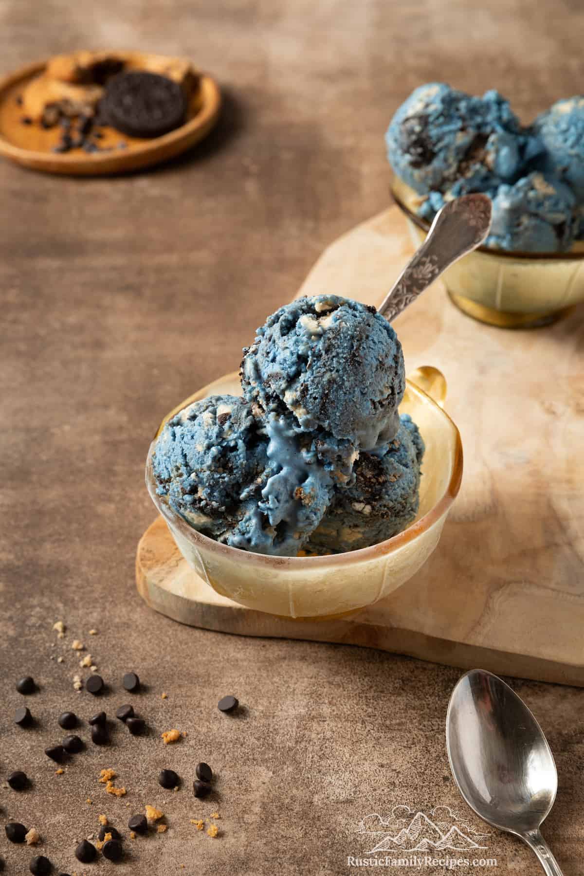 Three scoops of Cookie Monster ice cream in a bowl with a spoon.