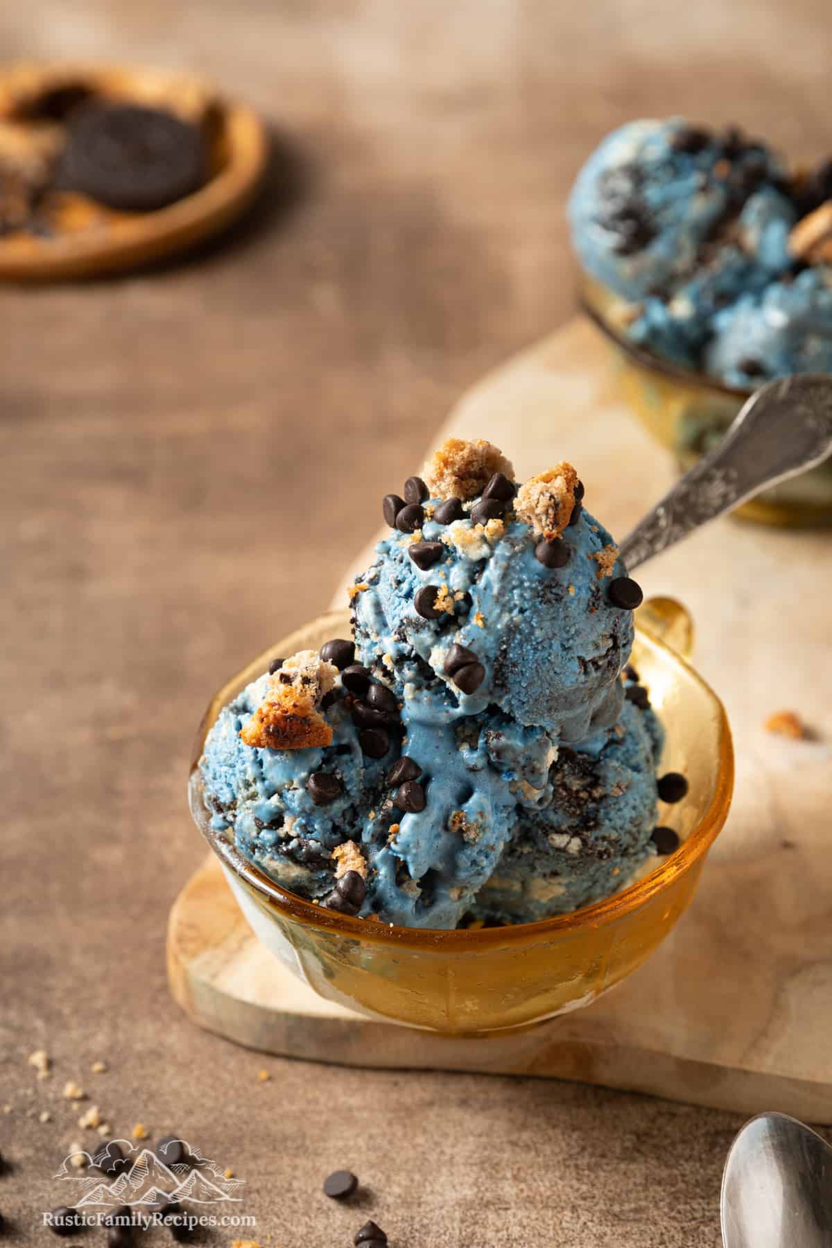 Close up of three scoops of Cookie Monster ice cream in a bowl with a spoon.