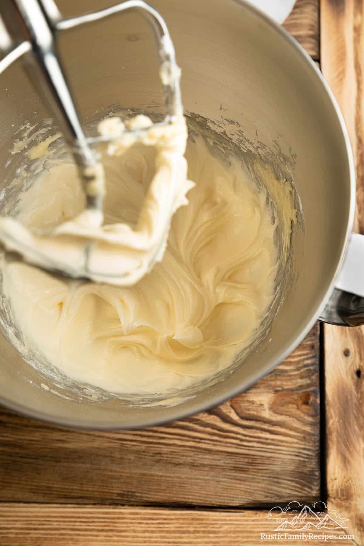 The wet ingredients for cake batter beaten in the bowl of a stand mixer.