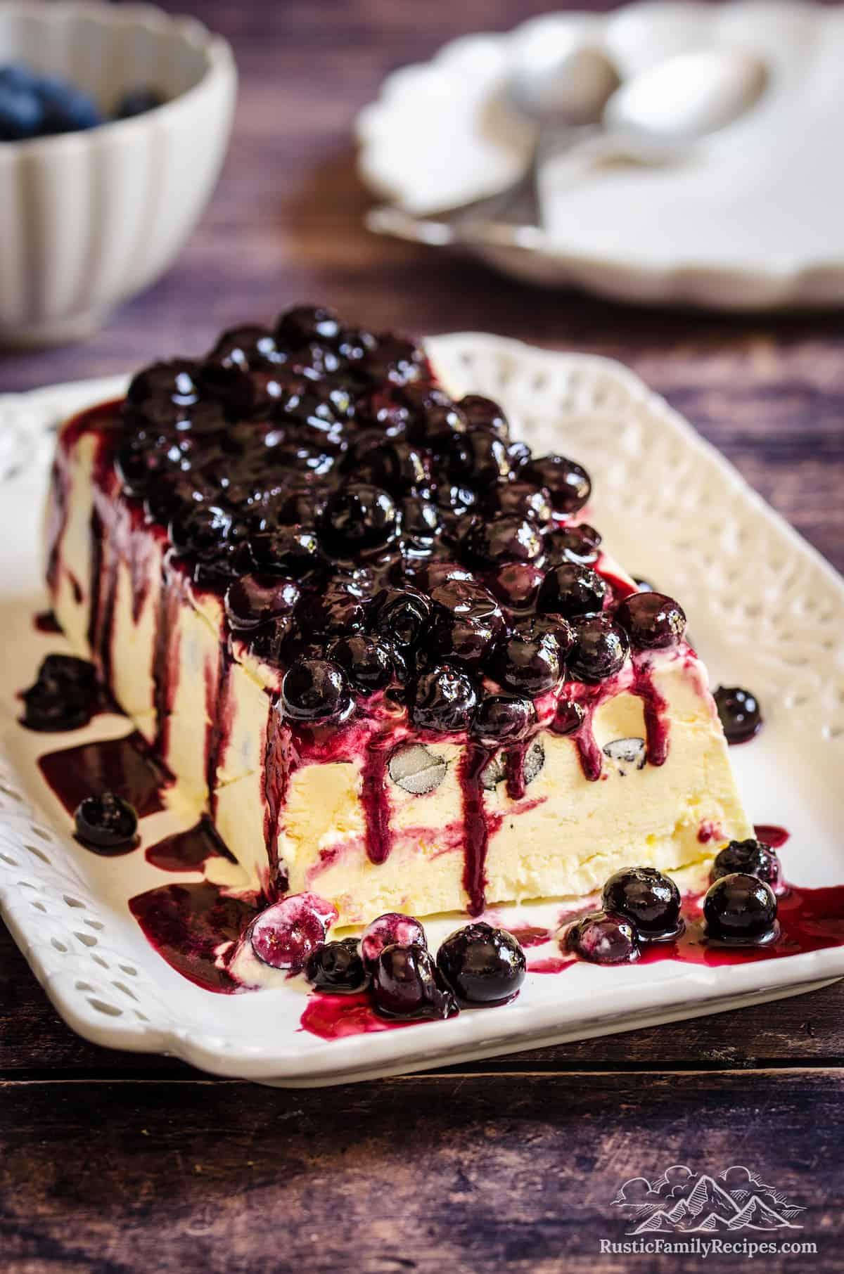 Lemon blueberry semifreddo on a plate topped with homemade blueberry sauce.