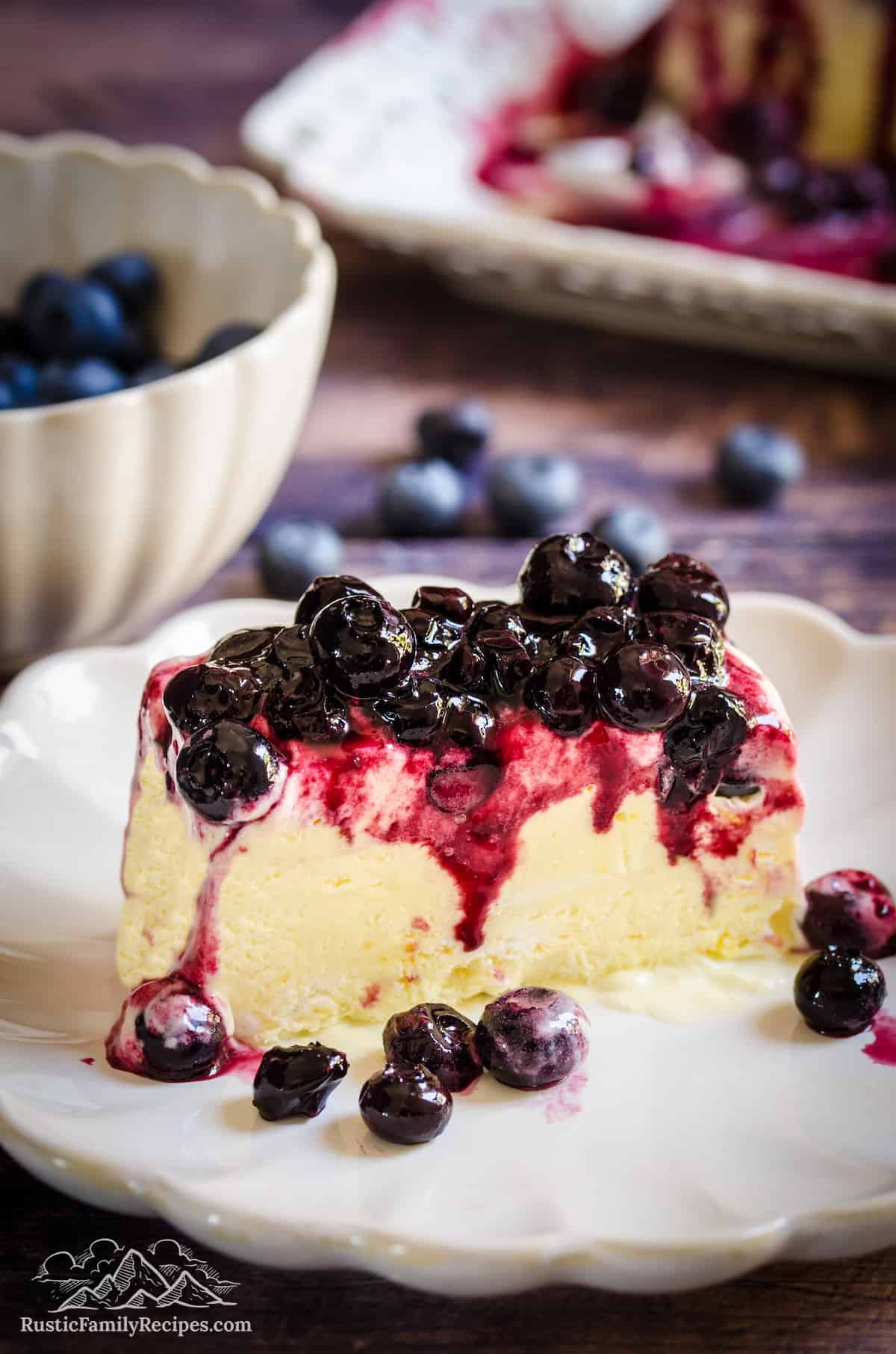 A slice of lemon blueberry semifreddo on a plate, topped with blueberry sauce.