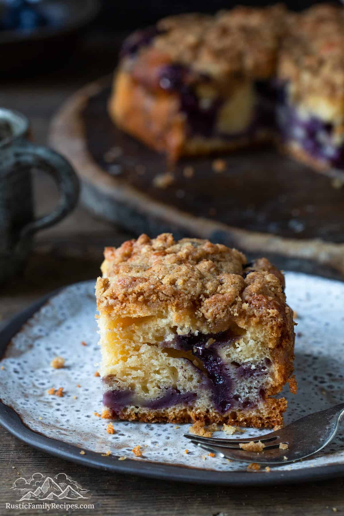 A slice of blueberry buckle on a plate.