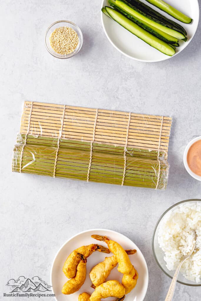 Rolling the bamboo mat over the fillings.