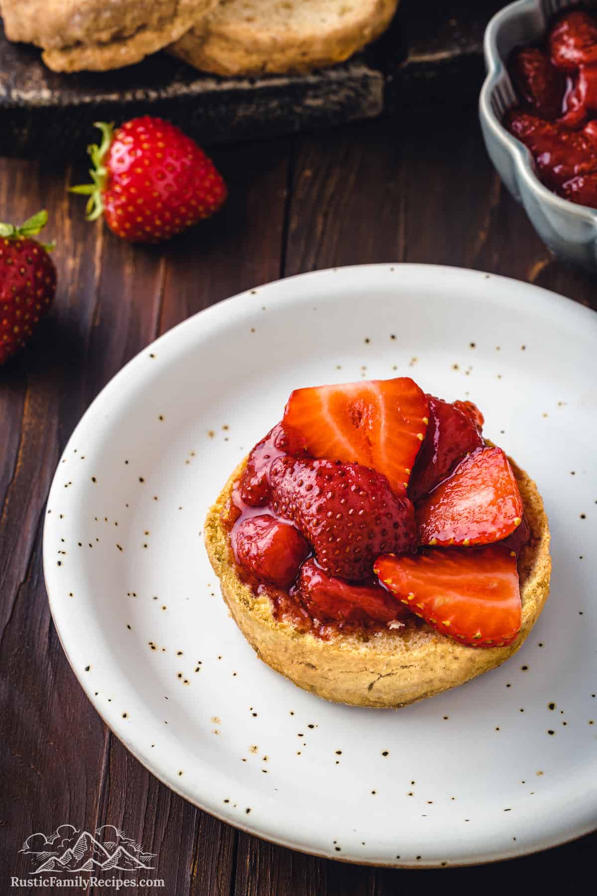 Strawberries on half a shortcake biscuit on a white plate