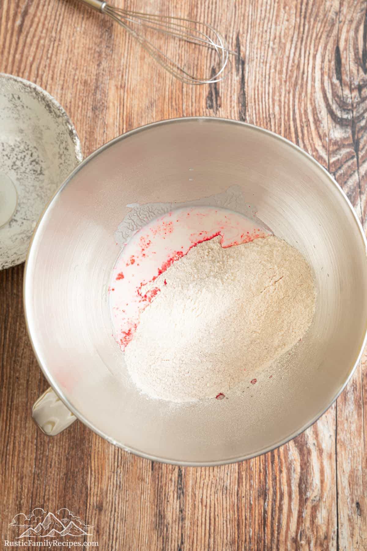 Flour and dragonfruit powder in a metal mixing bowl.