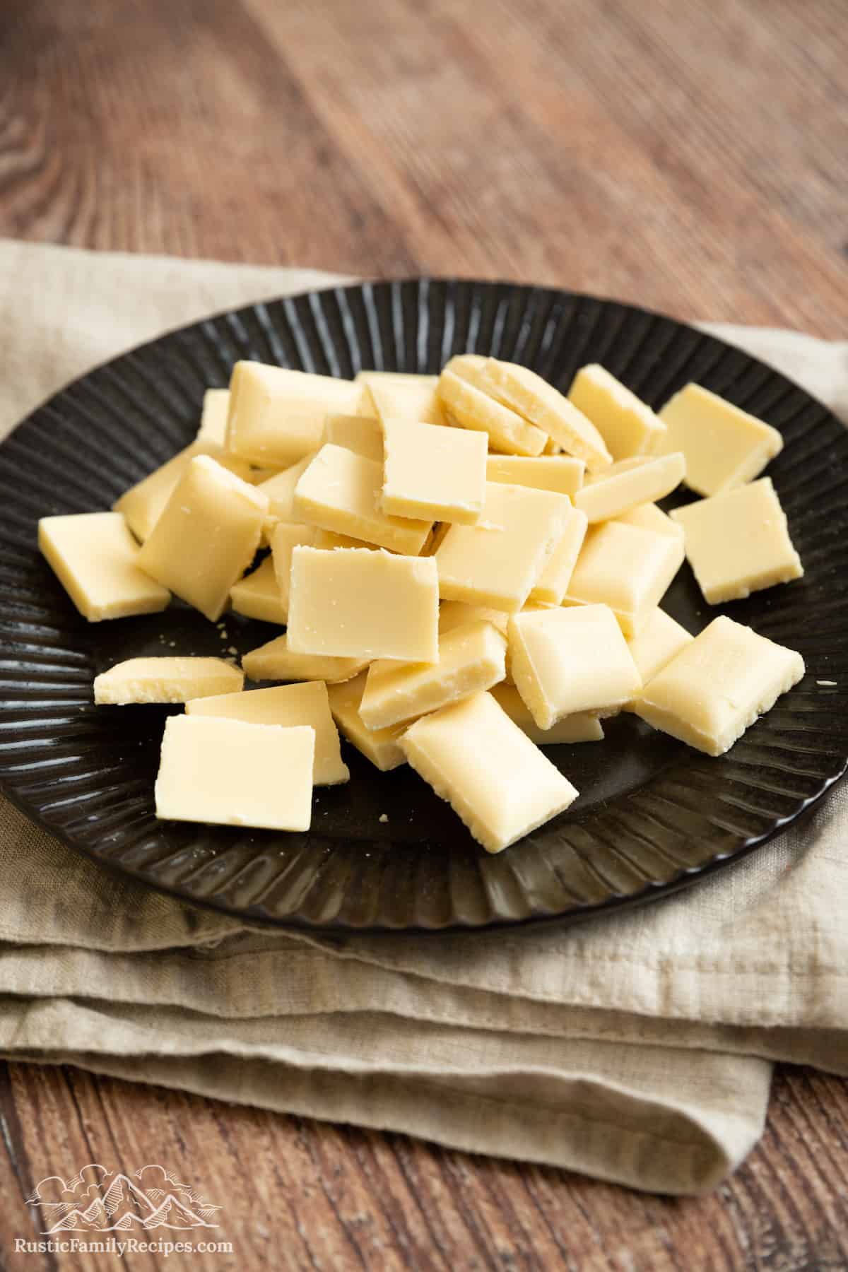 White chocolate pieces on a black plate.