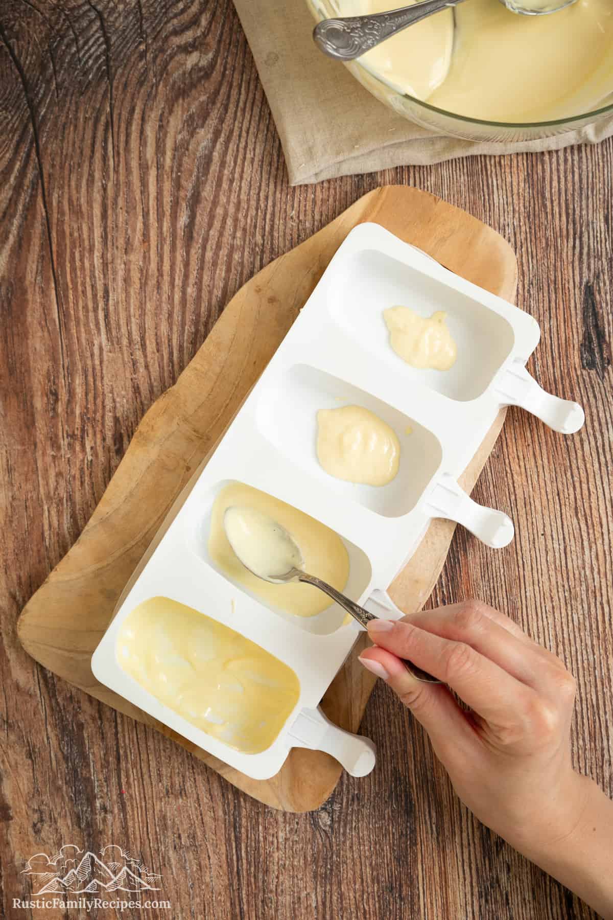 Melted white chocolate is added into the cakesicle molds.