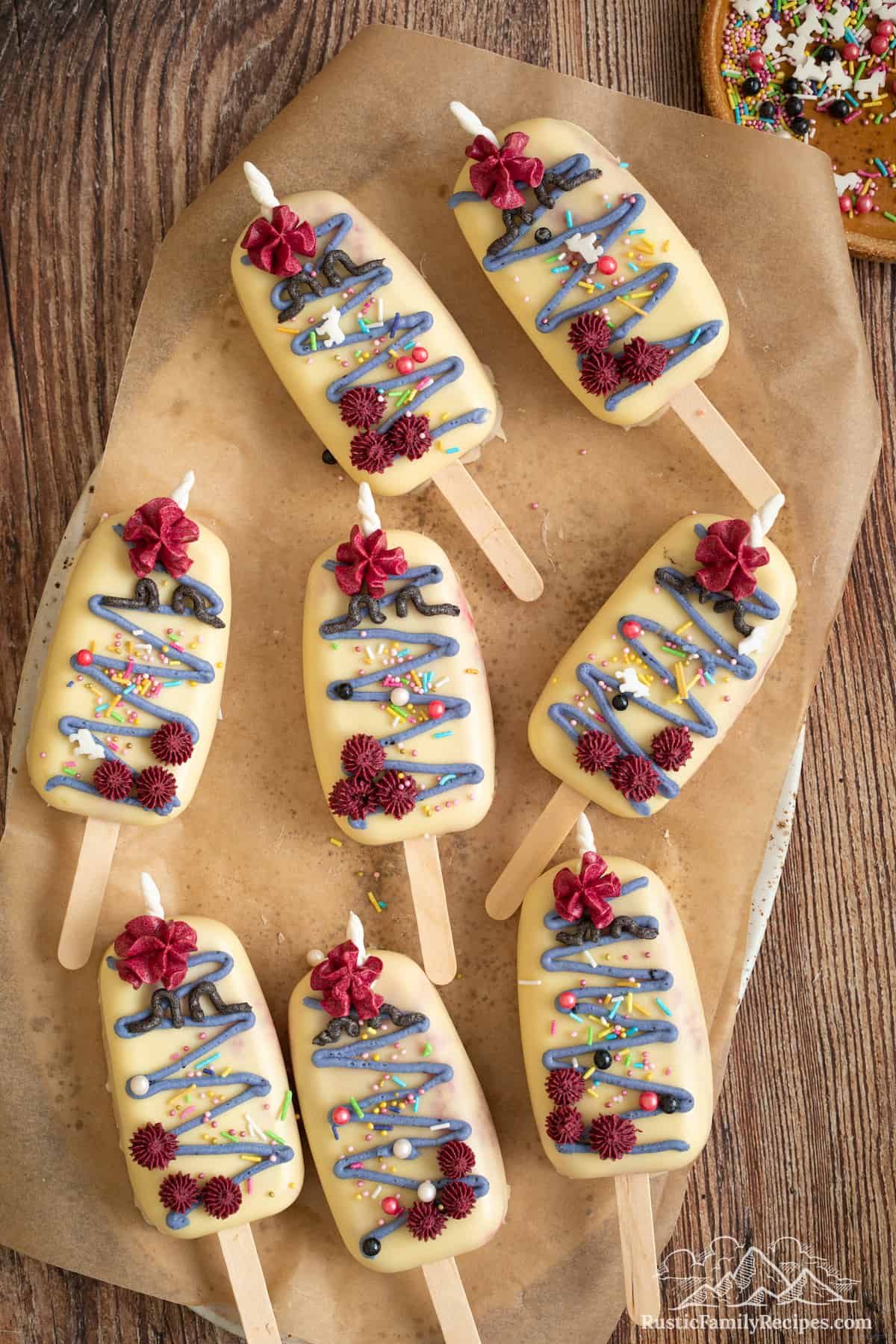 Decorated unicorn cakesicles on parchment paper.