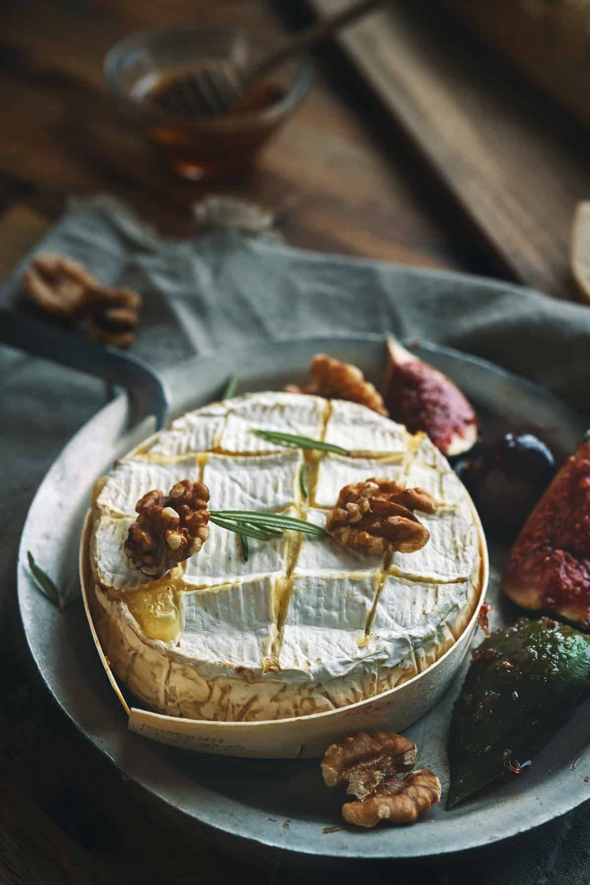 Baked camembert cheese on a plate with walnuts on top