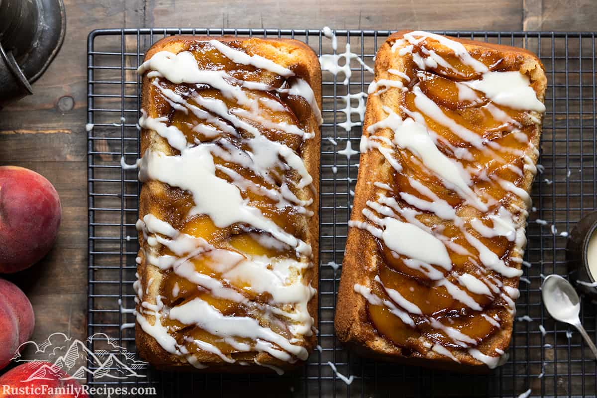 Two peach cobbler pound cakes on wire racks cooling