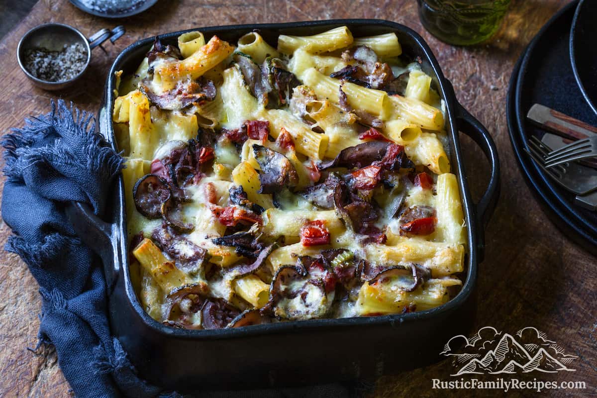 A baking dish with baked rigatoni and veggies