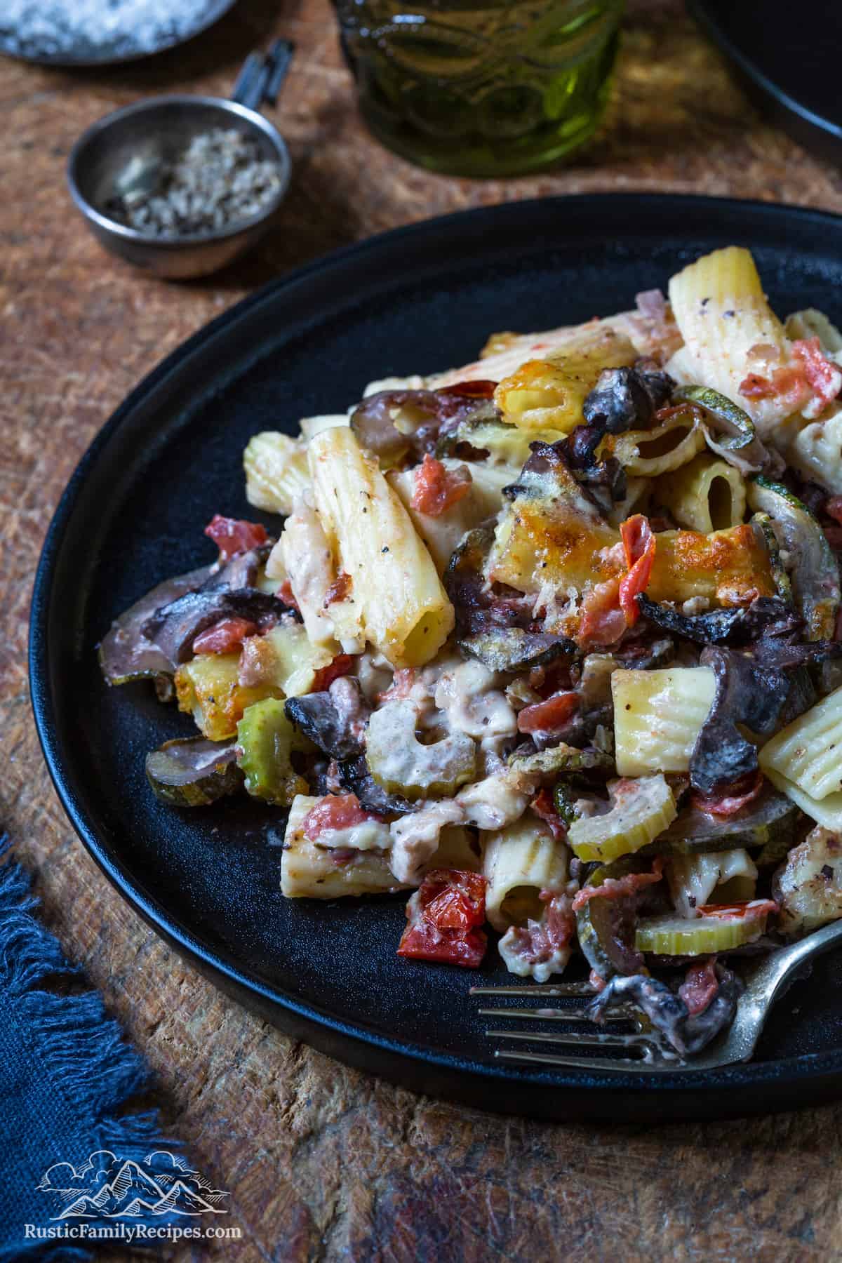 A plate with a generous serving of baked rigatoni pasta with veggies