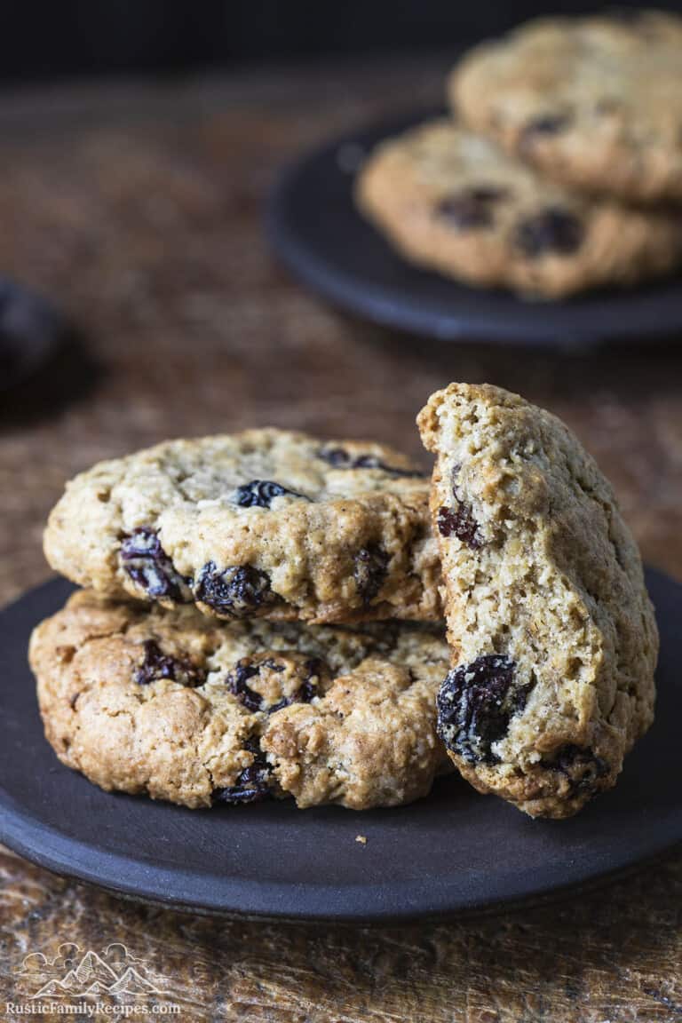 3 oatmeal raisin cookies on a plate, one with a bite taken out