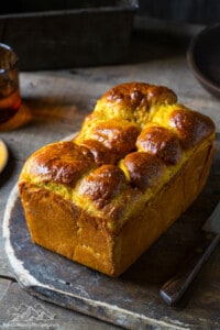 A loaf of pumpkin bread cooling on a block