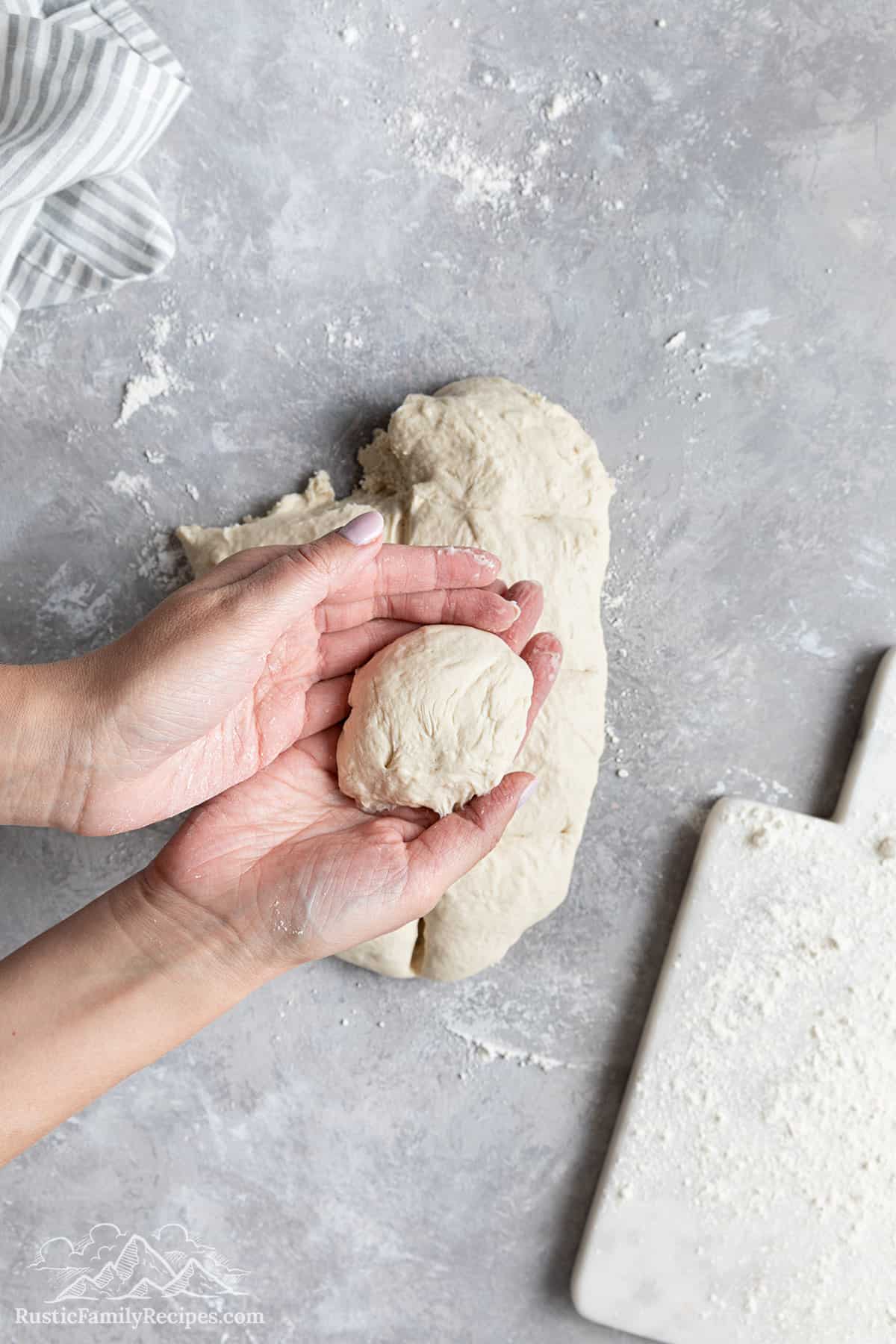 Rolling each portion of dough into a ball. 