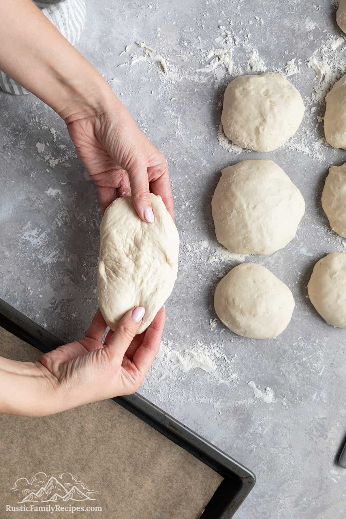 Stretching the telera dough into an oblong shape.