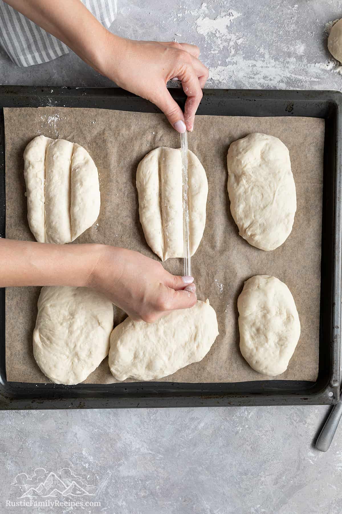 Making the second marking on each piece of dough with a straw.