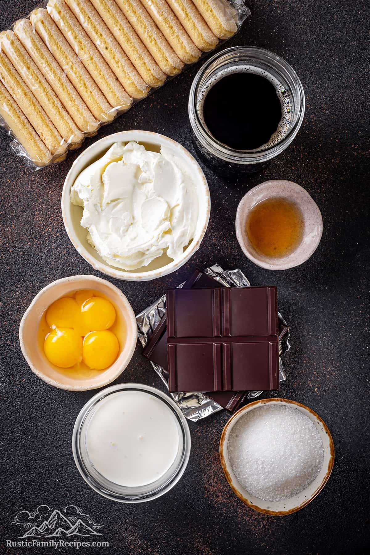 Tiramisu ingredients: mascarpone, egg yolks, coffee, sugar, heavy cream, Grand Marnier, ladyfingers, and chocolate.